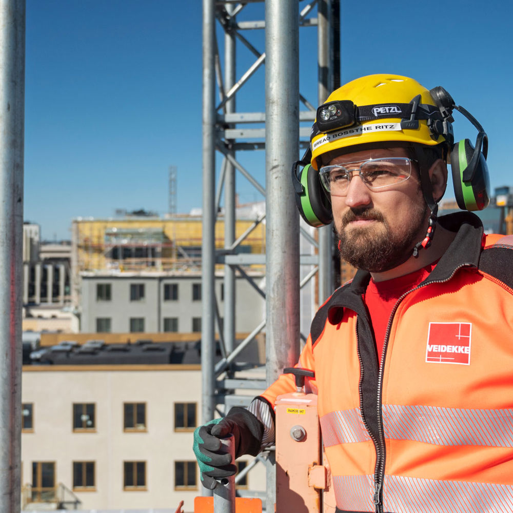 Foto av Veidekkes medarbetare Douglas Borgby. Står utomhus i varselkläder och hjälm.