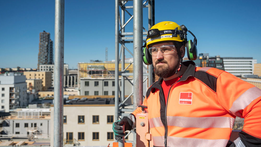 Foto av Veidekkes medarbetare Douglas Borgby. Står utomhus i varselkläder och hjälm.