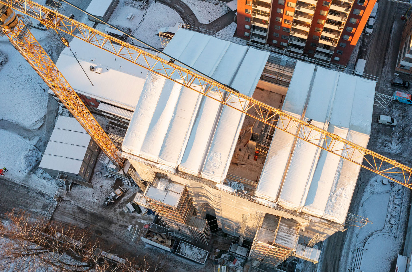 Drönarfoto över en byggkran och stor konstruktion av byggnadsställningar.
