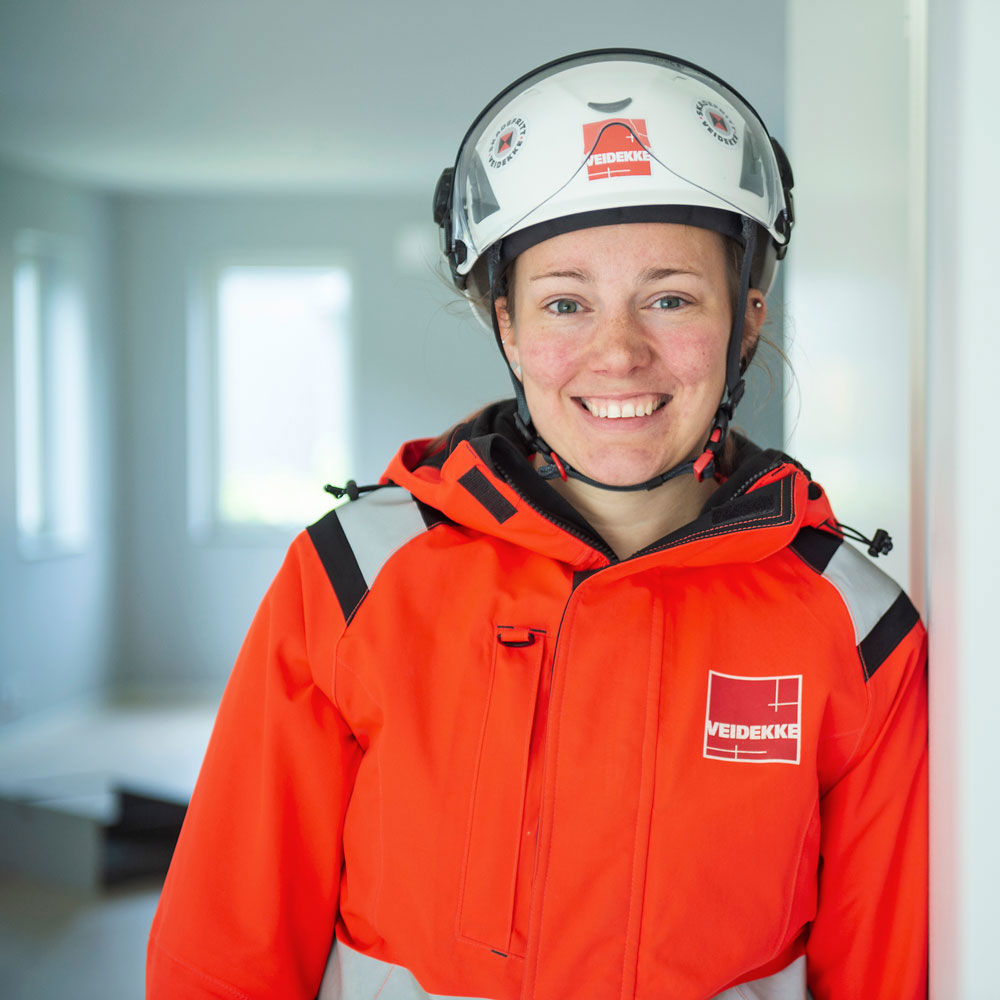 Veidekkes medarbetare Linnea Sernemyr står leende i varselkläder och hjälm.