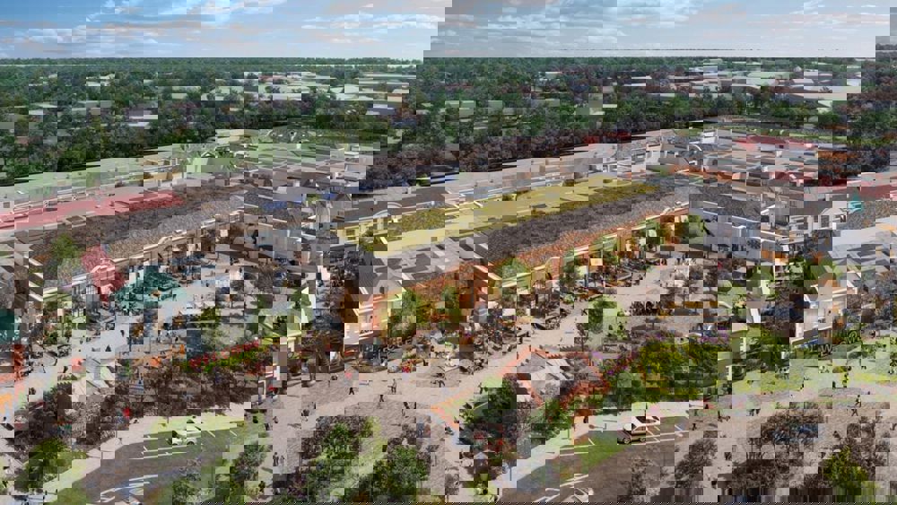 Flygbild över ett shoppingcenter med byggnader i traditionell stadsmiljö
