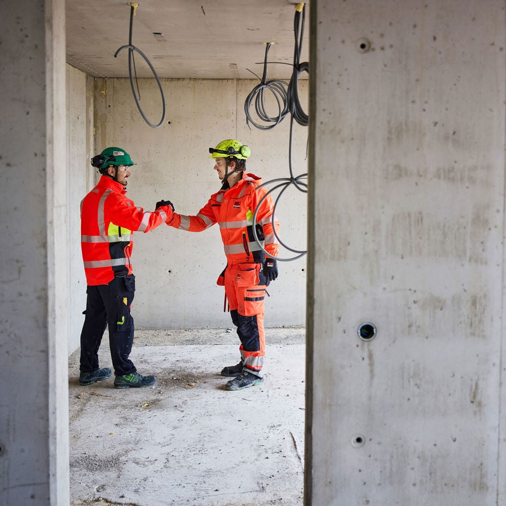 Två byggarbetare skakar hand