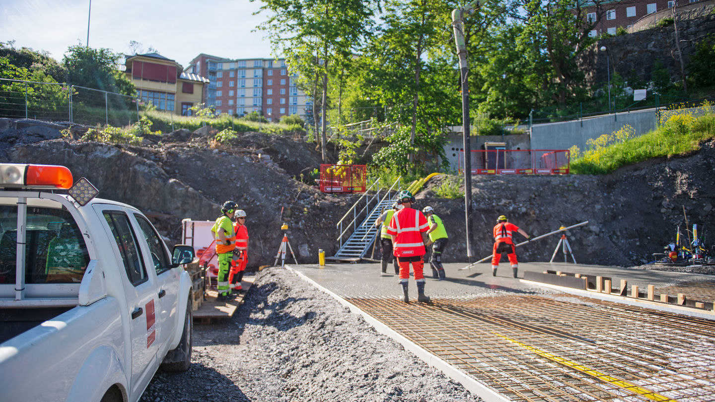 Veidekkemedarbetare gjuter en betongplatta.