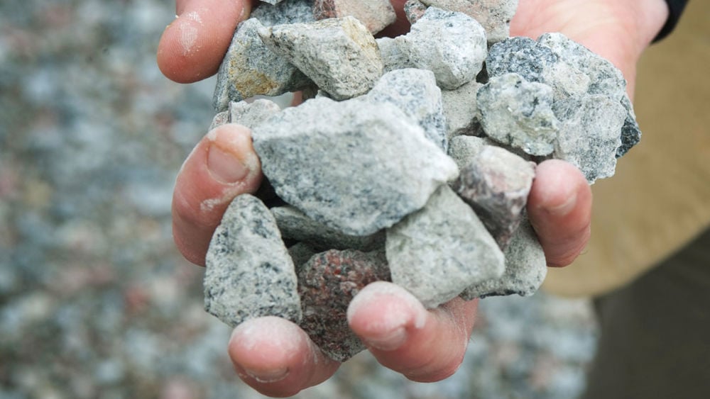 Närbild av en hand som håller i grus