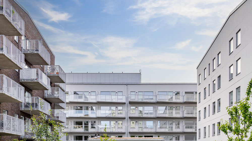 Foto av bostadsområde med lekplats i förgrunden.