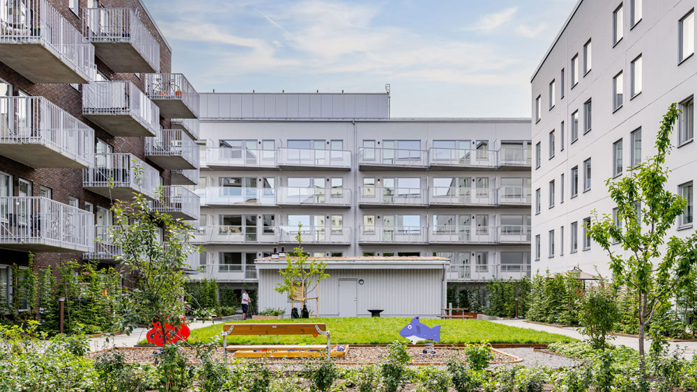 Foto av bostadsområde med lekplats i förgrunden.
