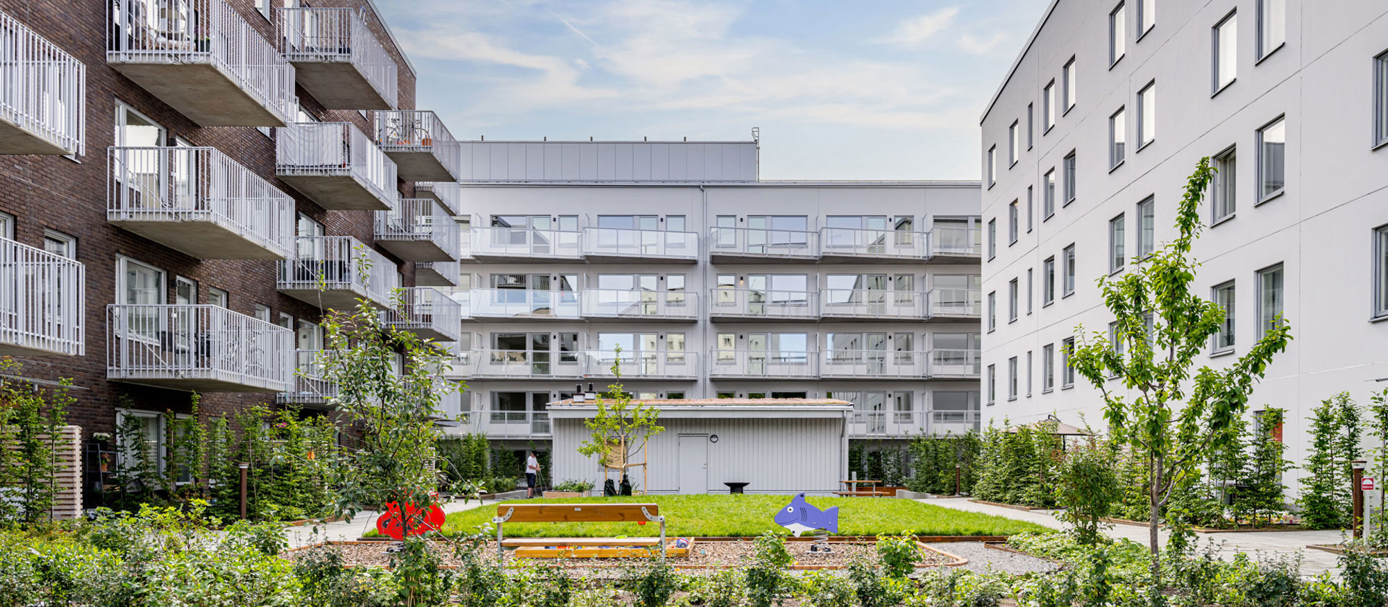 Foto av bostadsområde med lekplats i förgrunden.