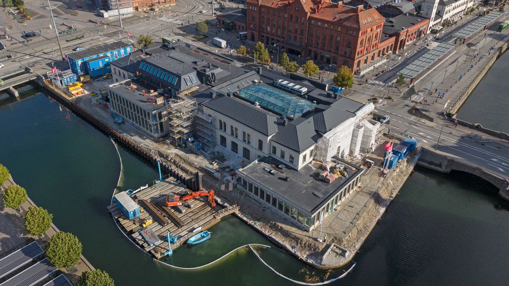 Flygbild över Börsen i Malmö - en pampig äldre byggnad omgiven av vatten på flera sidor
