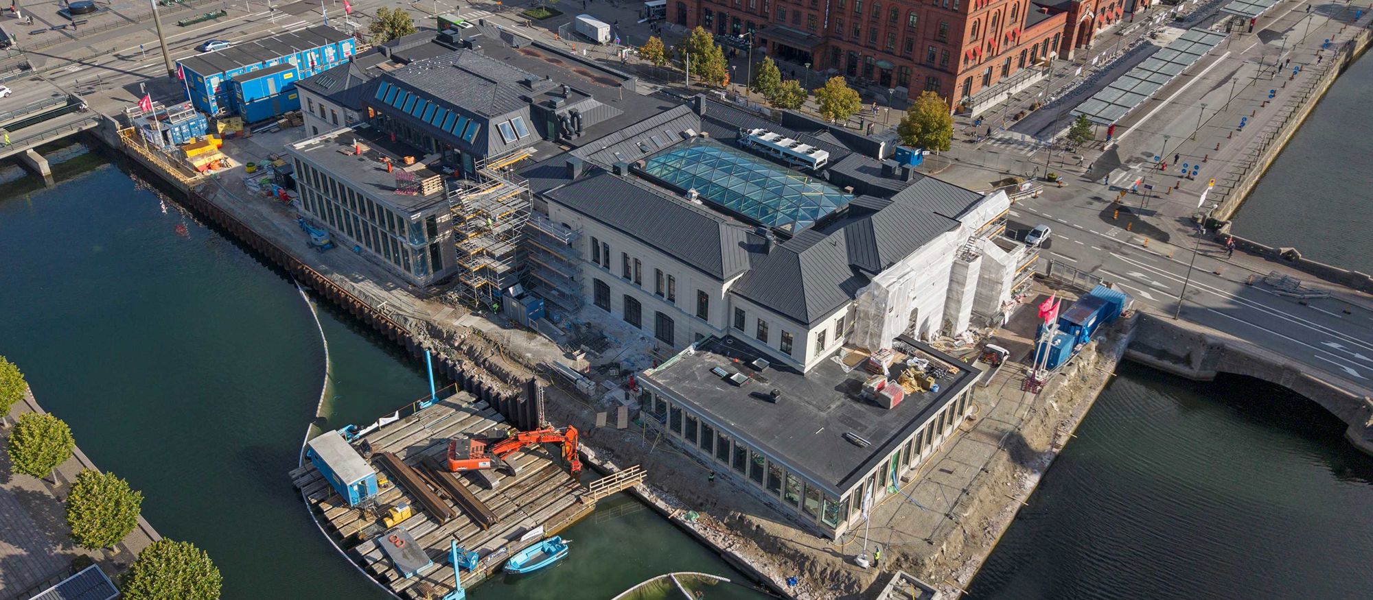 Flygbild över Börsen i Malmö - en pampig äldre byggnad omgiven av vatten på flera sidor