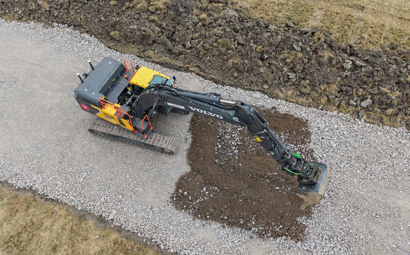 Grävmaskin i arbete på en grusväg