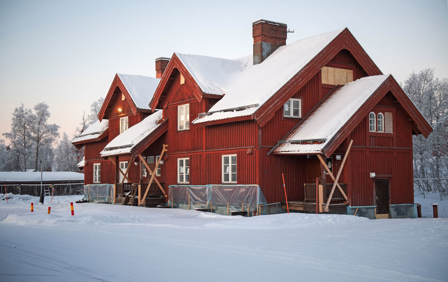 Foto av en röd stor byggnad täckt i snö.