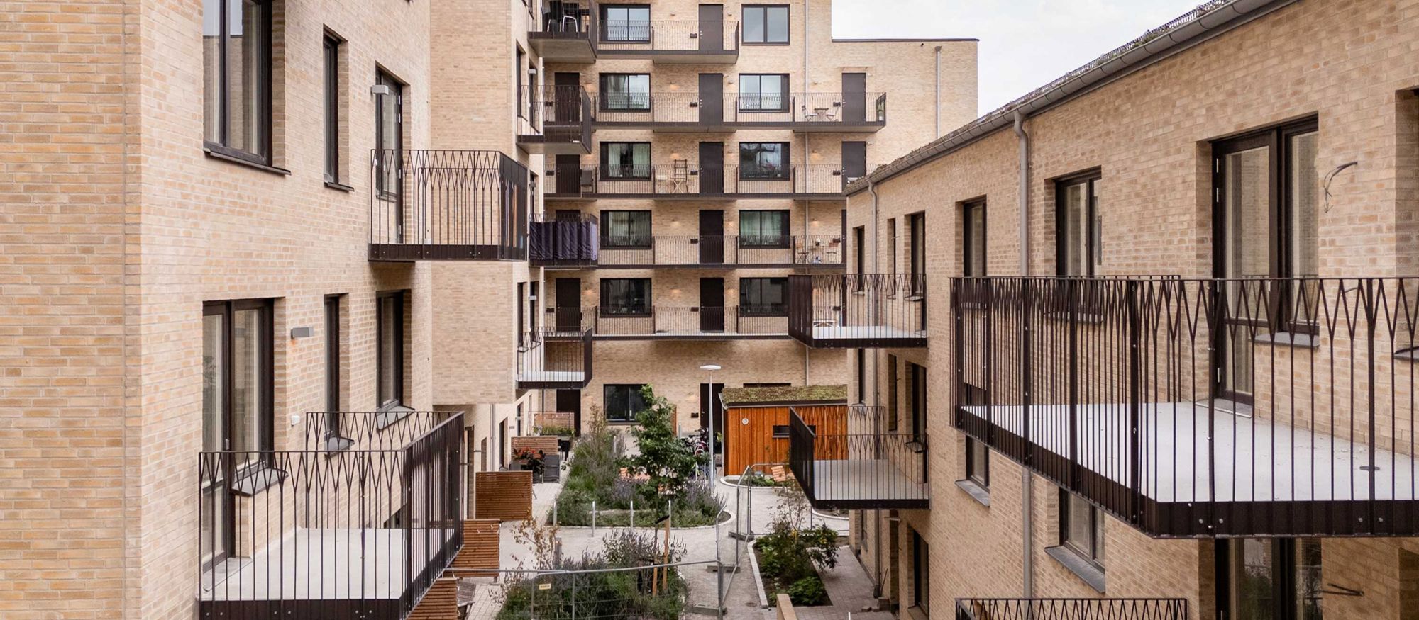 Sjuvåningshus med tegelfasad och lägenheter med balkonger. 