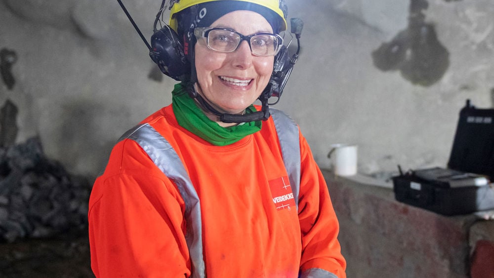 Leende kvinna som står i en tunnel.