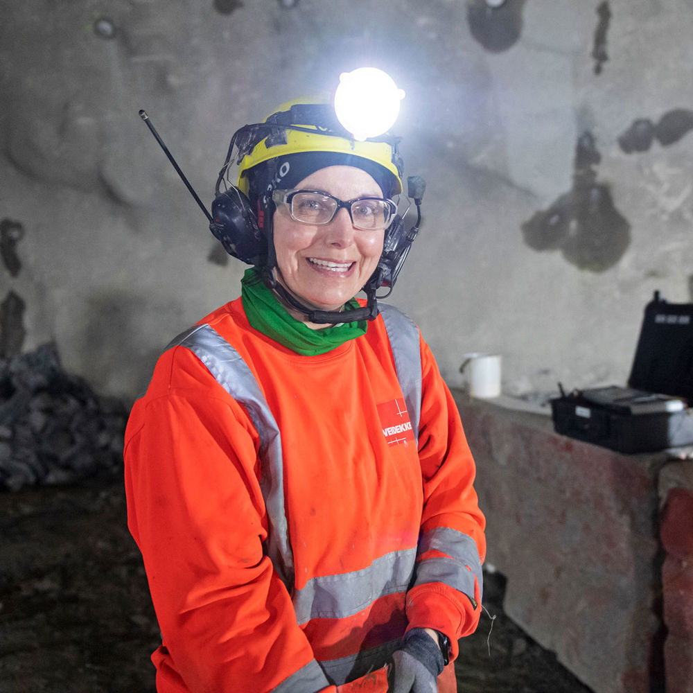 Leende kvinna som står i en tunnel.