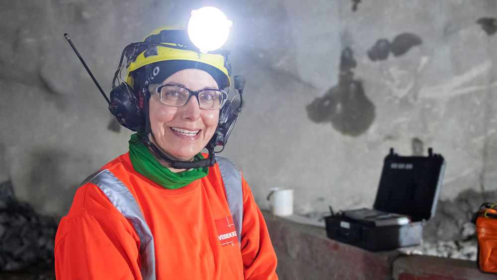 Leende kvinna som står i en tunnel.