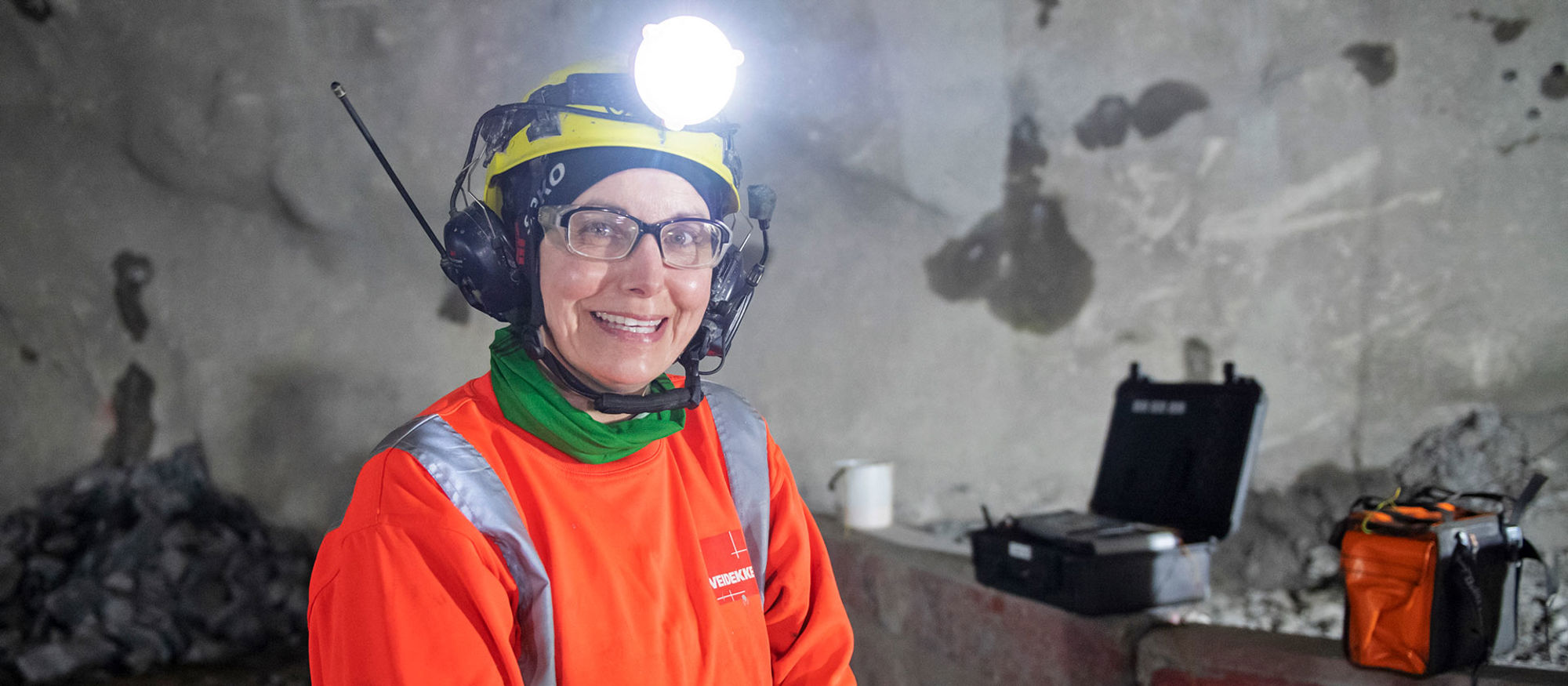Leende kvinna som står i en tunnel.