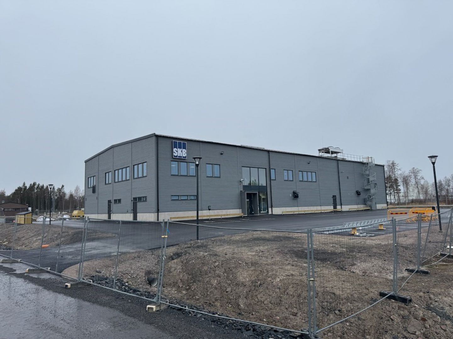 Färdigbyggd geologibyggnad med grå fasad och SKB:s skylt på plats