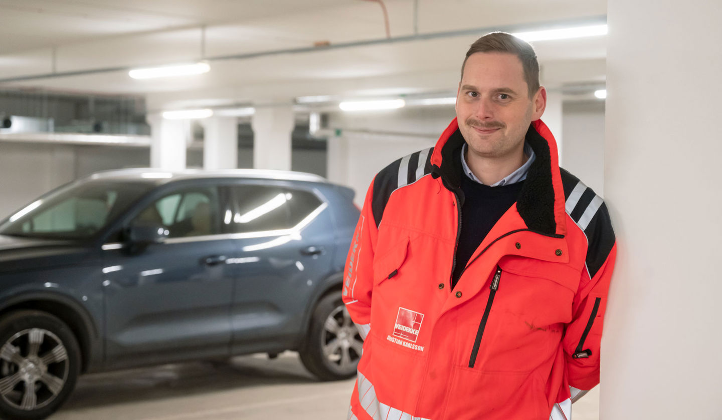 Foto av leende Veidekke-medarbetare i varseljacka.
