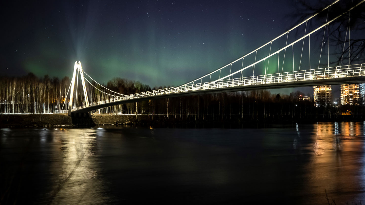 Foto av Lundabron med norrsken i bakgrunden.
