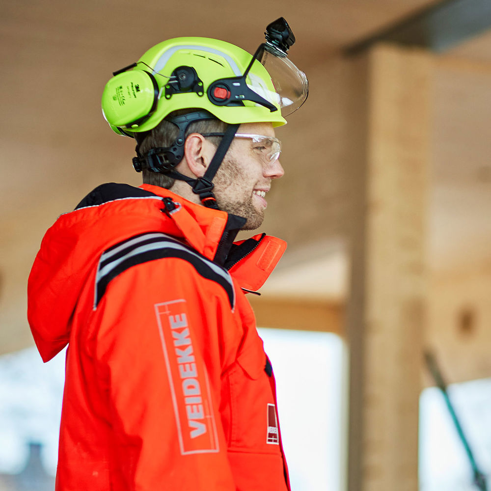 Foto av en person klädd i varselkläder och bygghjälm.