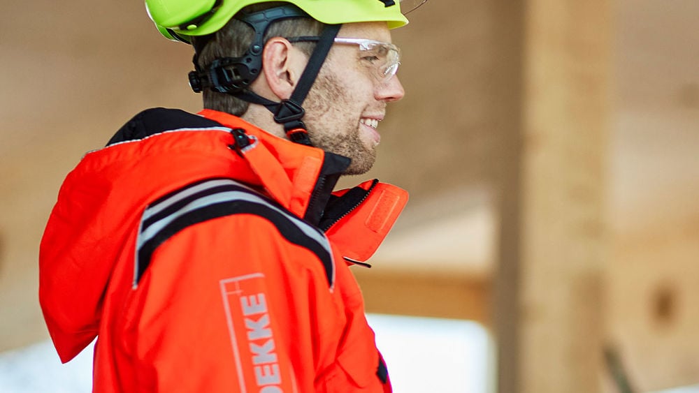 Foto av en person klädd i varselkläder och bygghjälm.