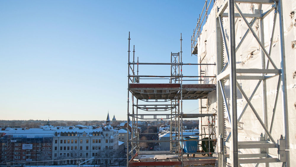 Foto av en byggnadsställning med blå himmel i bakgrunden.