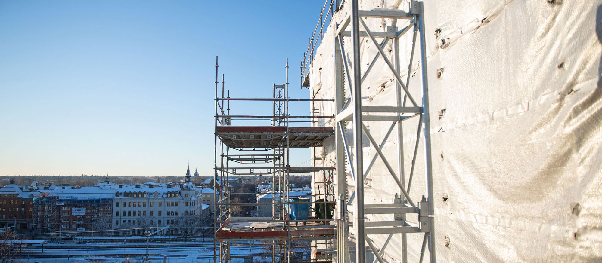Foto av en byggnadsställning med blå himmel i bakgrunden.