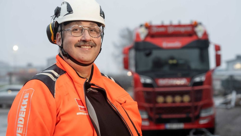Leende man i orange varseljacka och hjälm -  Anders Berntsson, arbetschef för Veidekke Grundläggning SydVäst,