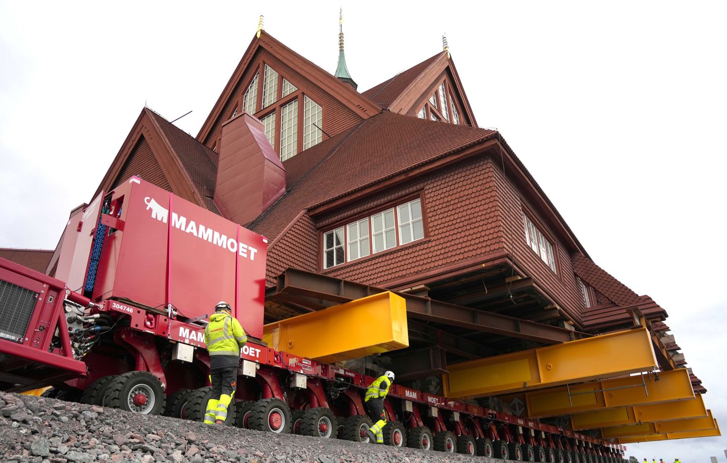 Bild av Kiruna kyrka, en stor röd träbyggnad som sitter på en trailer.