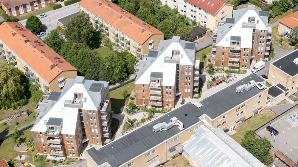 Grönalund. Tre hus i sju våningar med träfasad. 