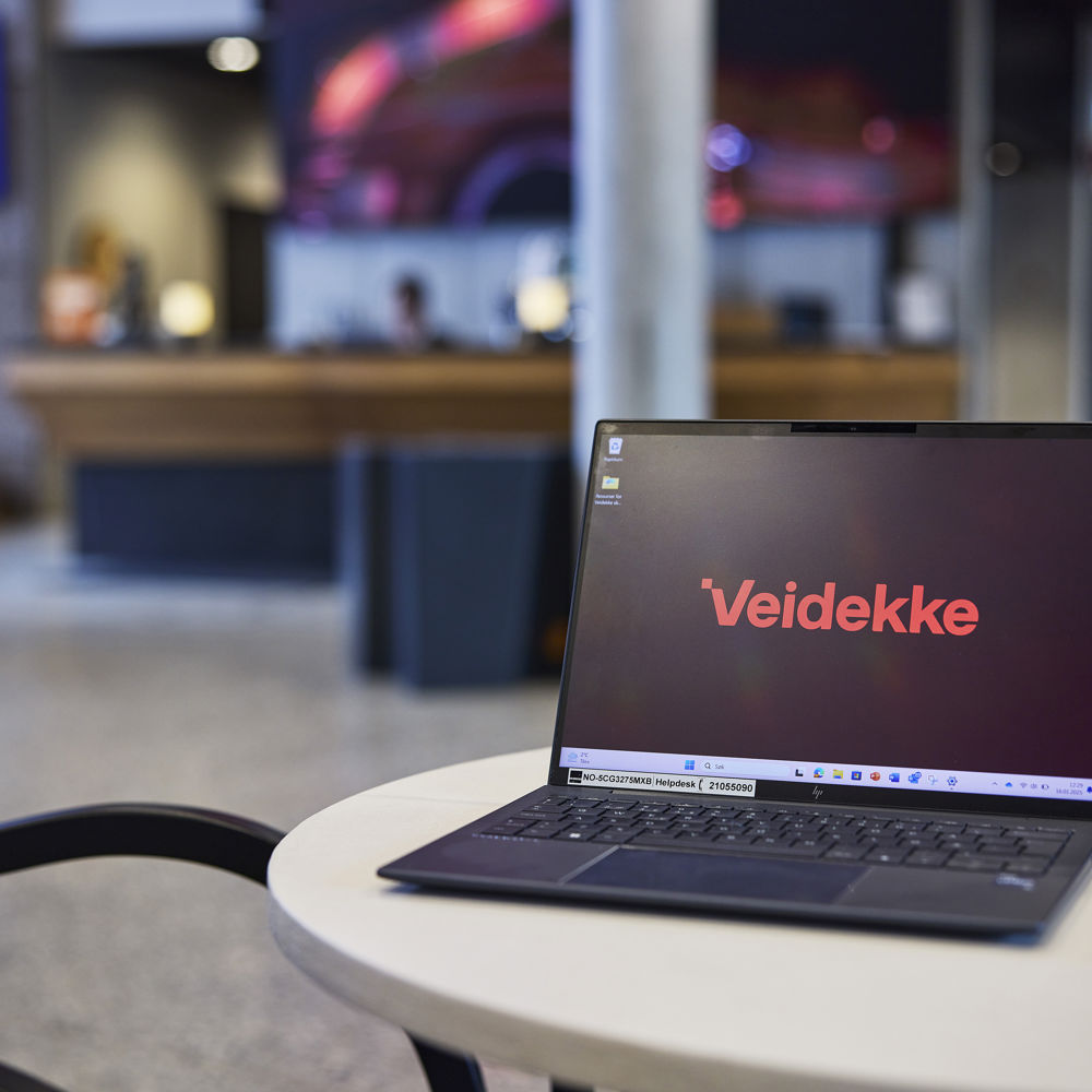 Bärbar dator vars skärm visar Veidekkes logga