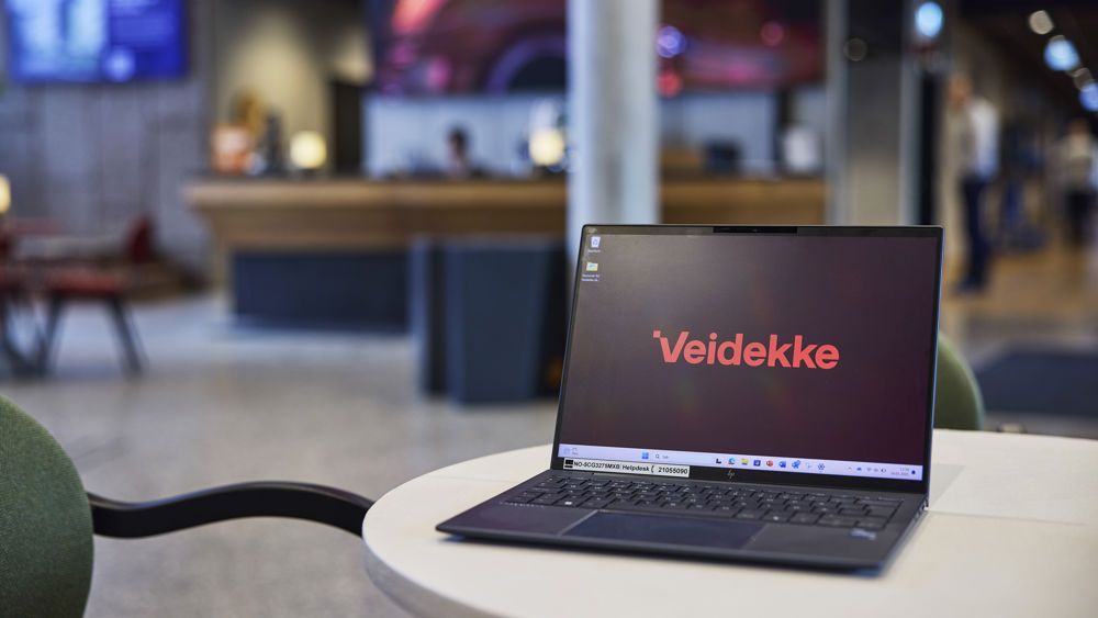 Bärbar dator vars skärm visar Veidekkes logga