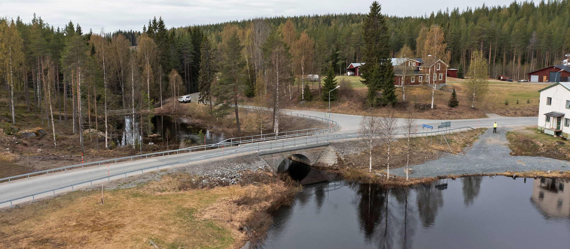 Stenbro över Bjurselebäcken med skog i bakgrunden.