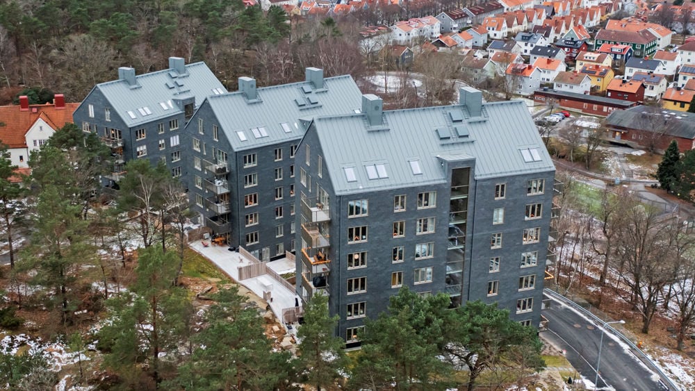 Foto av de tre huskropparna klädda i skiffer som bildar bostadsrätterna Kattugglan.
