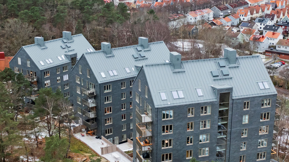 Foto av de tre huskropparna klädda i skiffer som bildar bostadsrätterna Kattugglan.