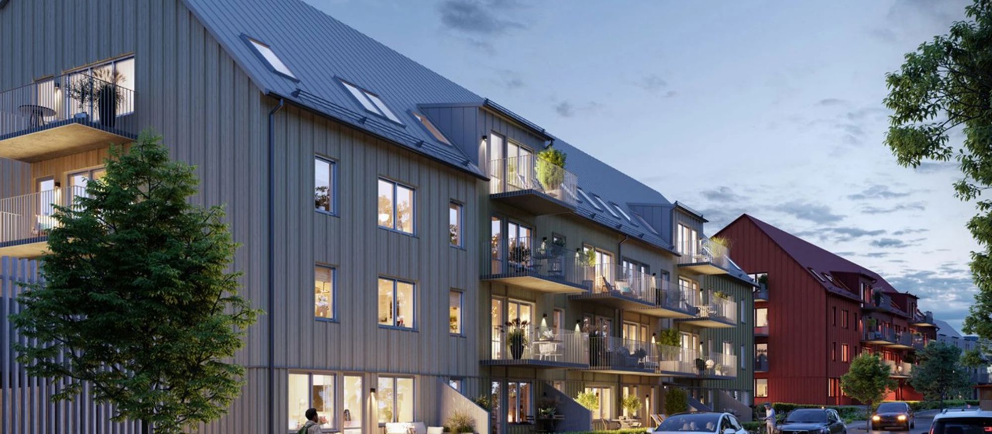 Grått trevåningshus med träpanel och mysiga balkonger - Brf Aroma