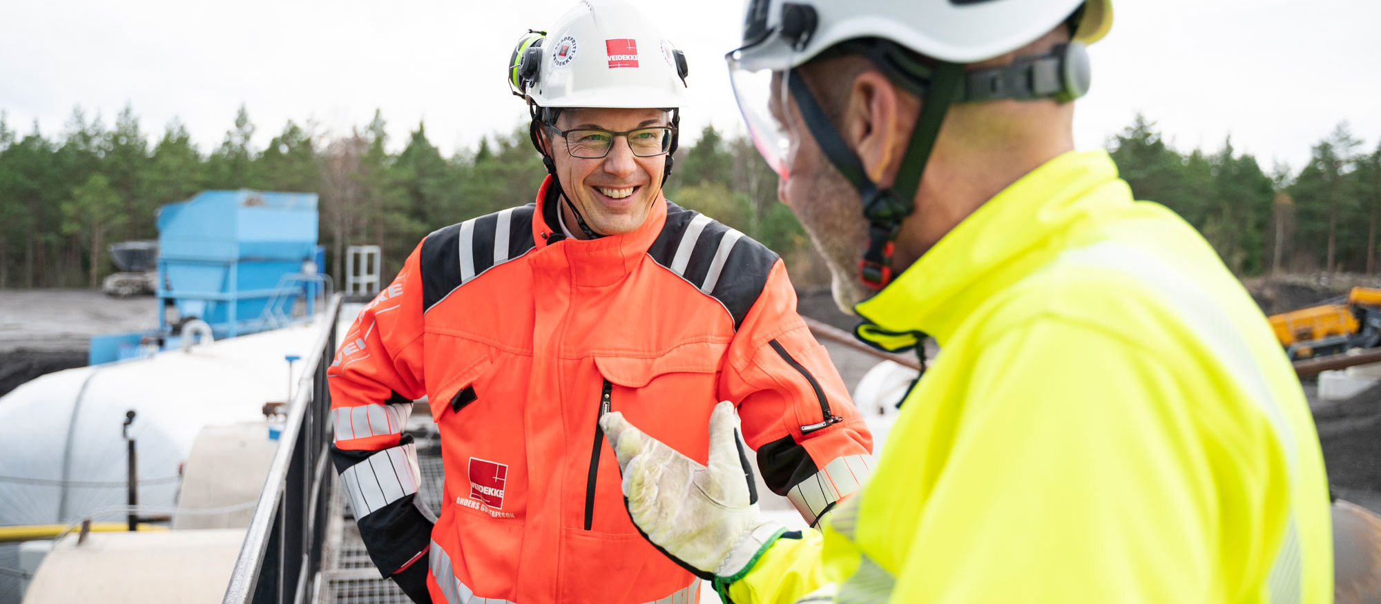 Man står leende och pratar med en kollega.