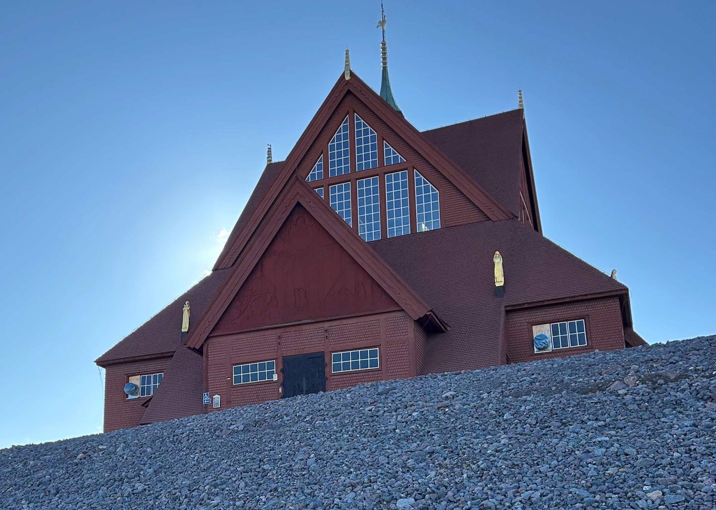 Bild av Kiruna kyrka. Röd träbyggnad täckt av snö