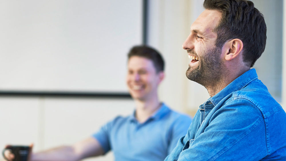 Leende man vid ett konferensbord