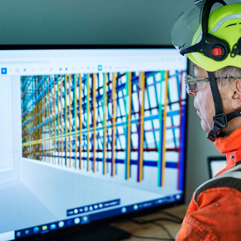En yrkesarbetare går igenom digitala ritningar via en BIM-kiosk