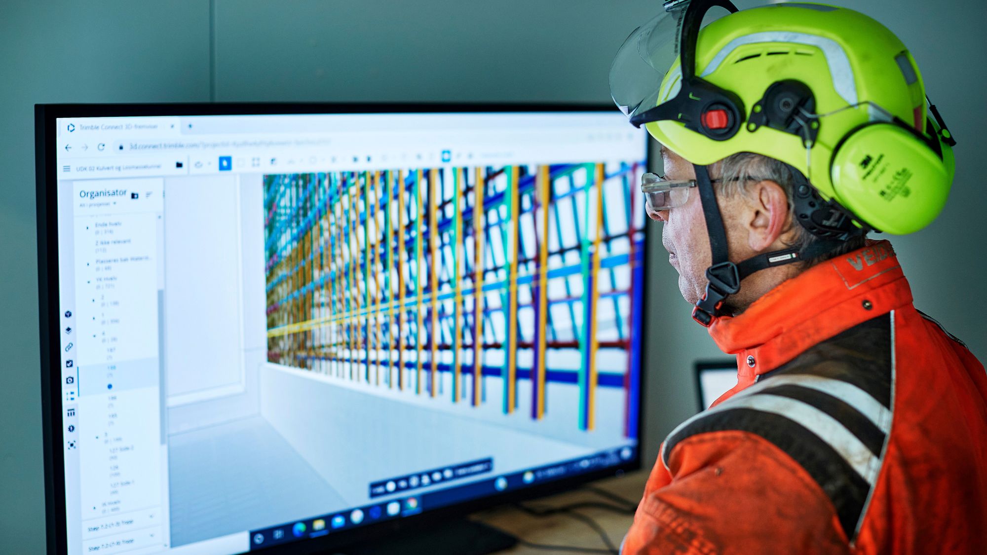 En yrkesarbetare går igenom digitala ritningar via en BIM-kiosk