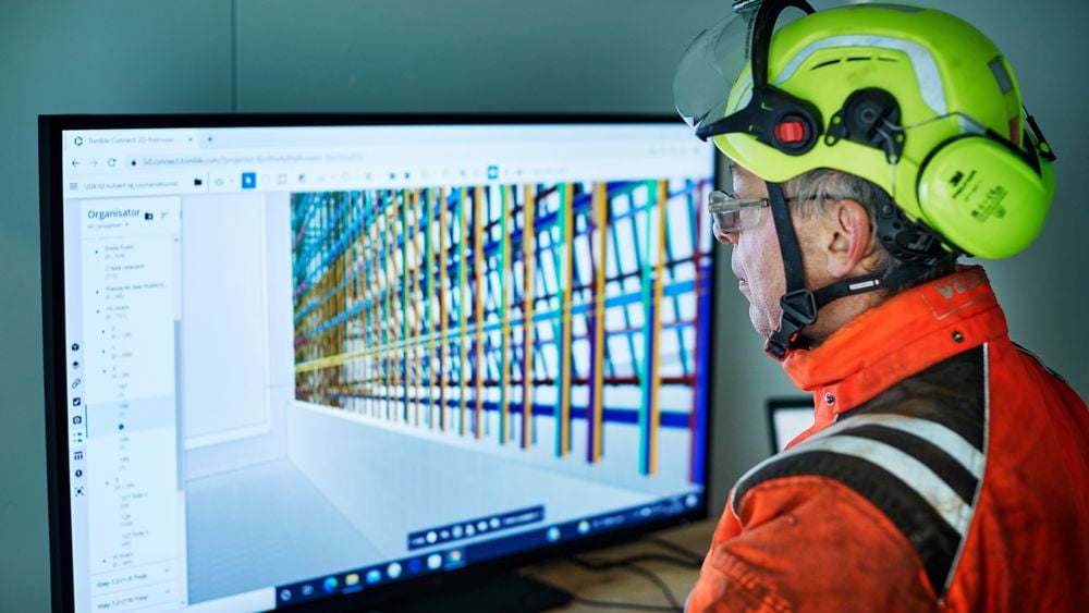 En yrkesarbetare går igenom digitala ritningar via en BIM-kiosk