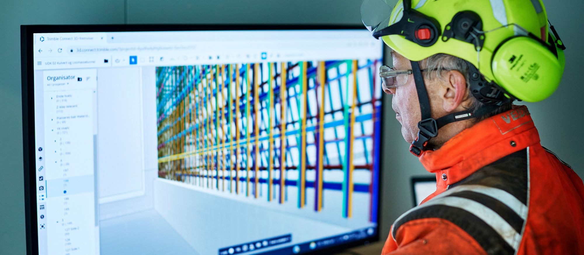 En yrkesarbetare går igenom digitala ritningar via en BIM-kiosk