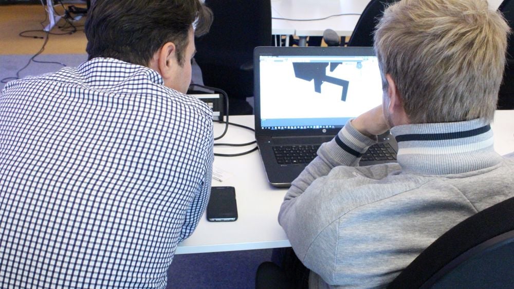 Två personer arbetar med en BIM-ritning på en dator. Endast deras ryggar syns.