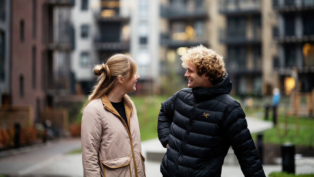 En kvinna och en man utanför ett flerbostadshus