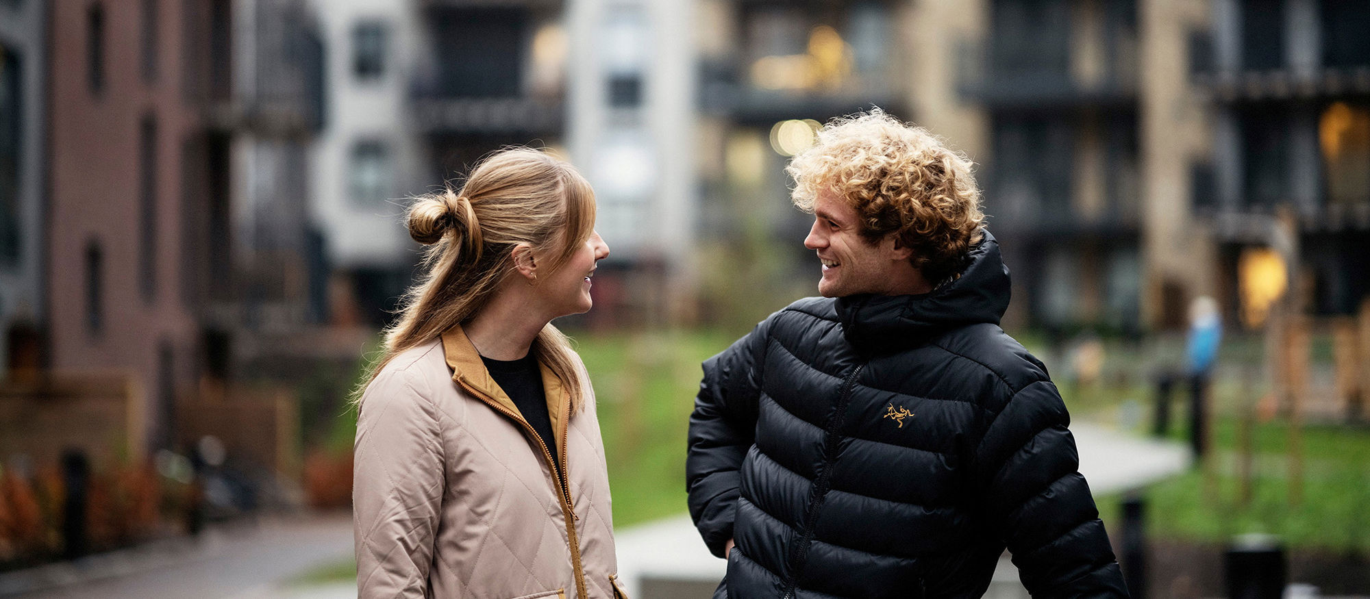 En kvinna och en man utanför ett flerbostadshus