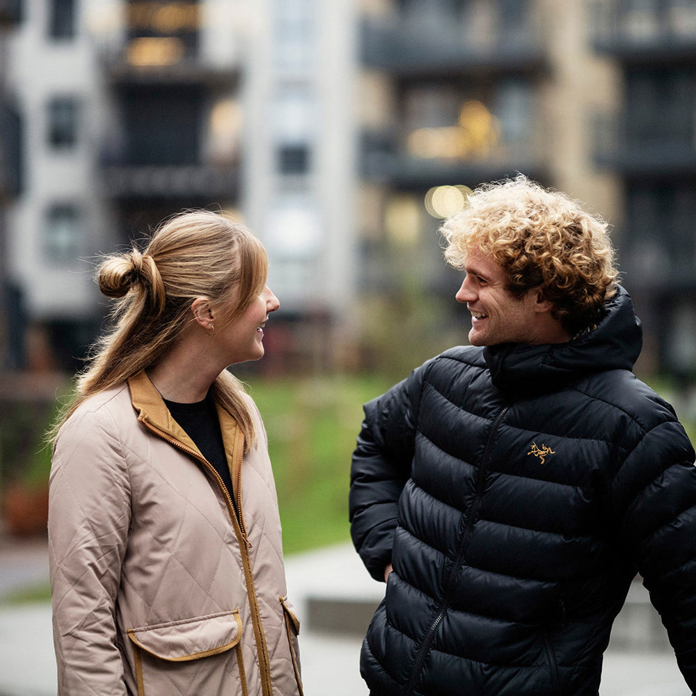 En kvinna och en man utanför ett flerbostadshus