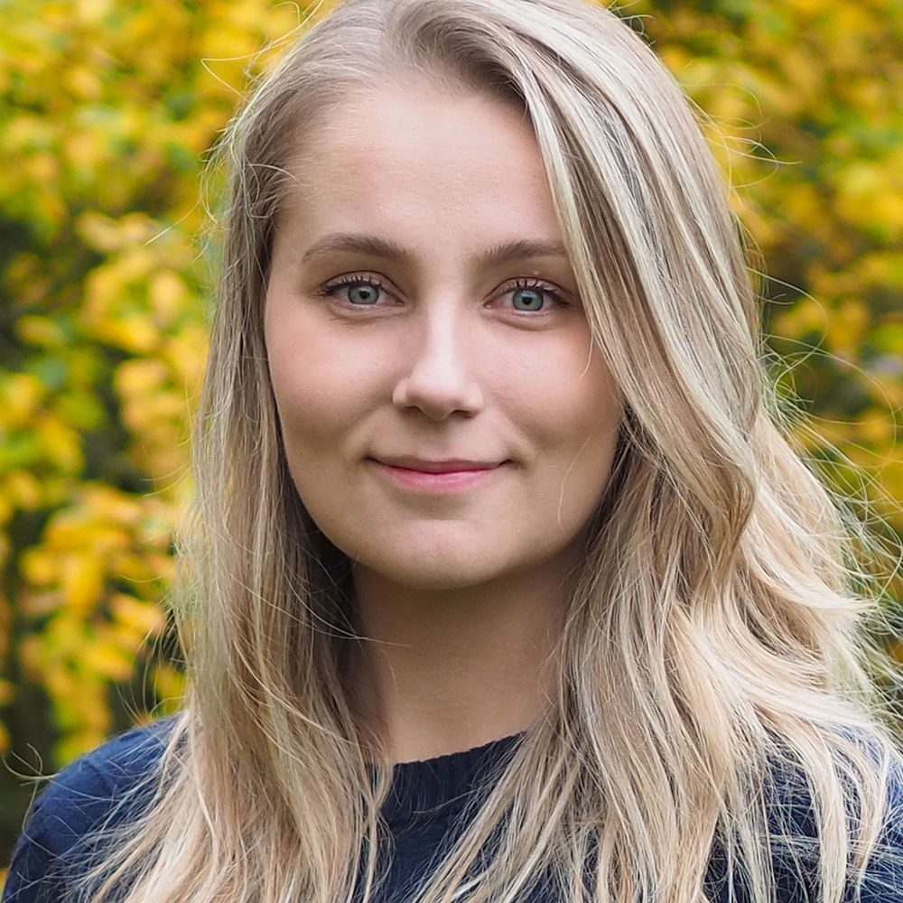 Josefine Olsson, blond kvinna framför gulgrönt buskage