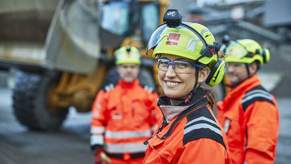 Byggarbetare, en kvinna i förgrunden med män i bakgrunden