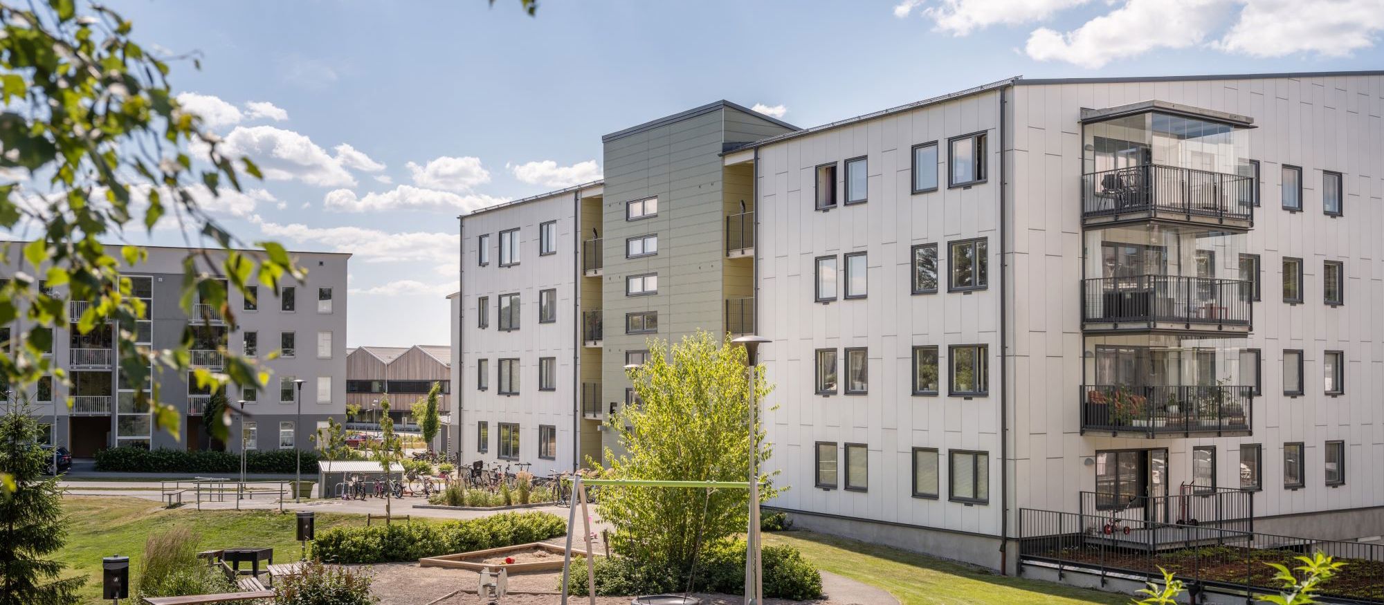 Brf Berget, Alsike. Exetriör med lekplats och gräsmatta
